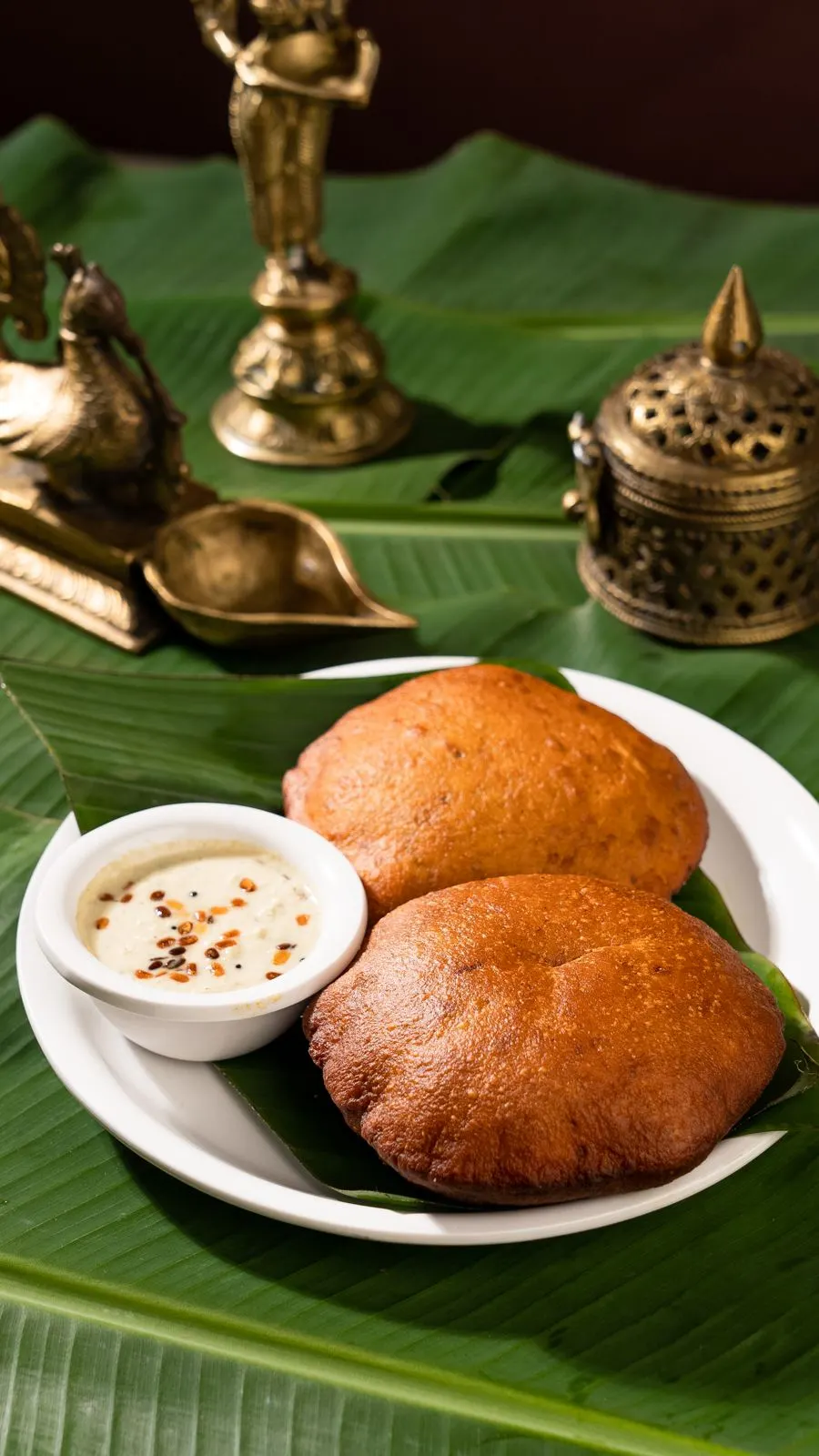 Sudarshan appams with coconut chutney on a banana leaf