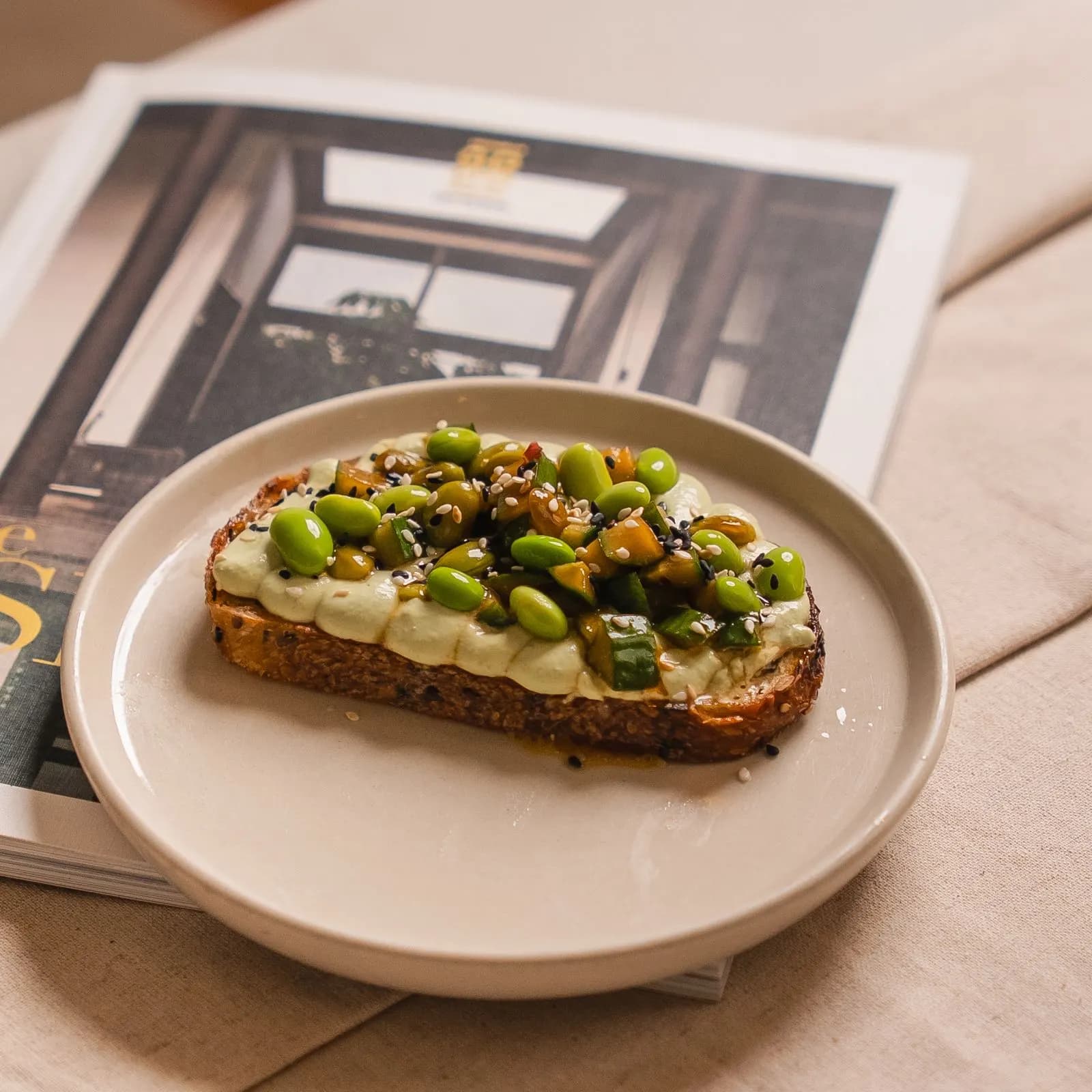 Vanilla Miel edamame hummus and truffle toast on a cream plate, shot in soft even daylight